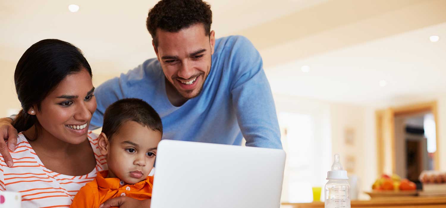 Young family with an open laptop