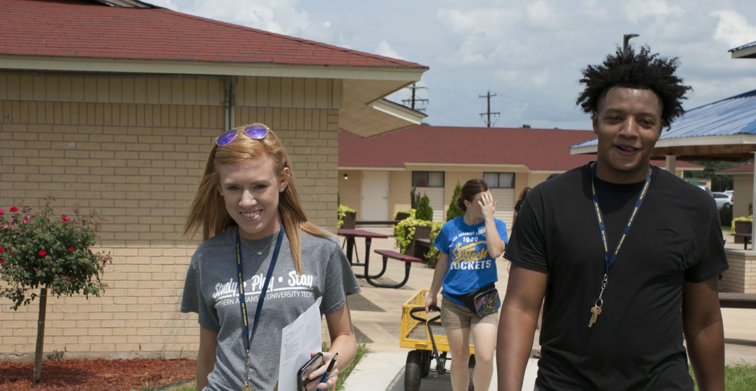 young male and female college students walking outside
