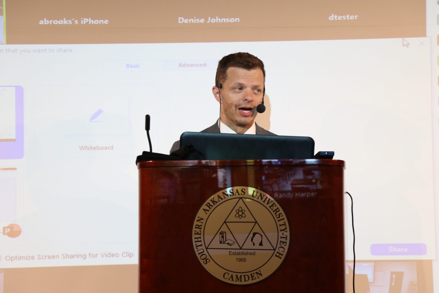 man in suit talking at podium