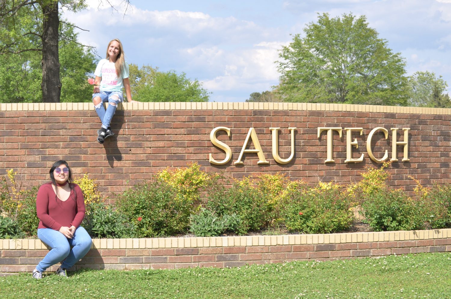 Students in front of a sign that says sau tech