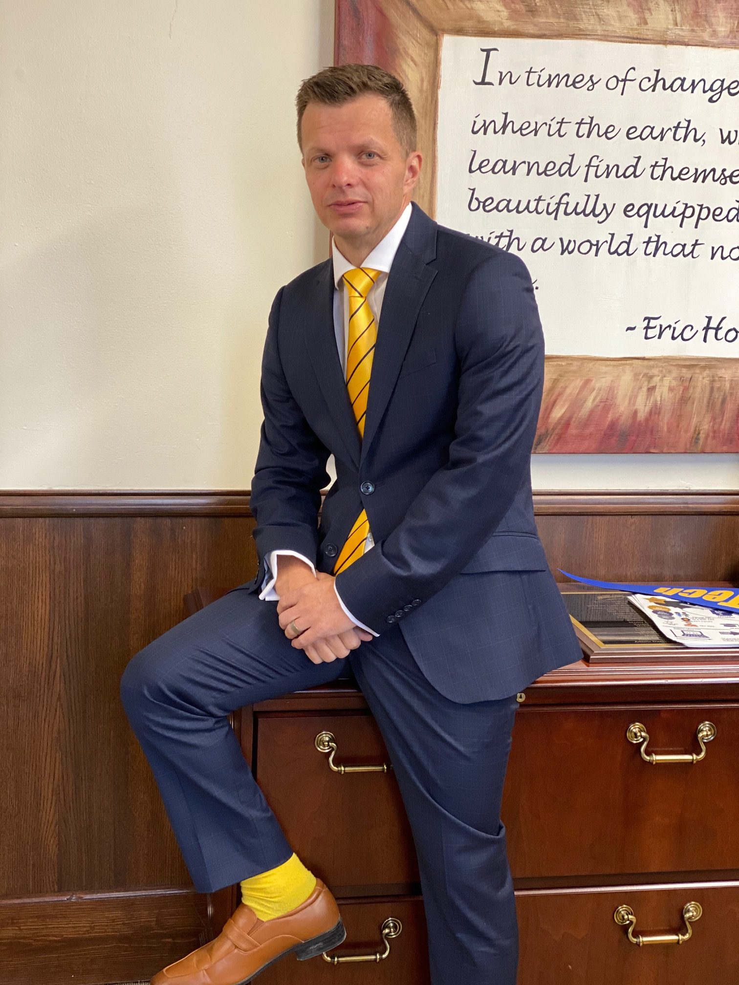 man in blue suit with yellow socks and tie