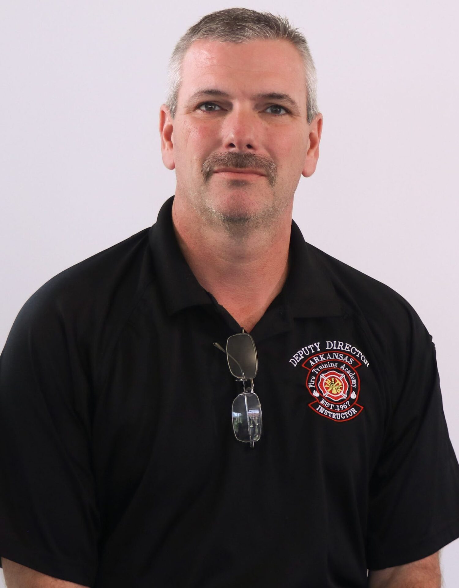 Man with gray hair in black polo