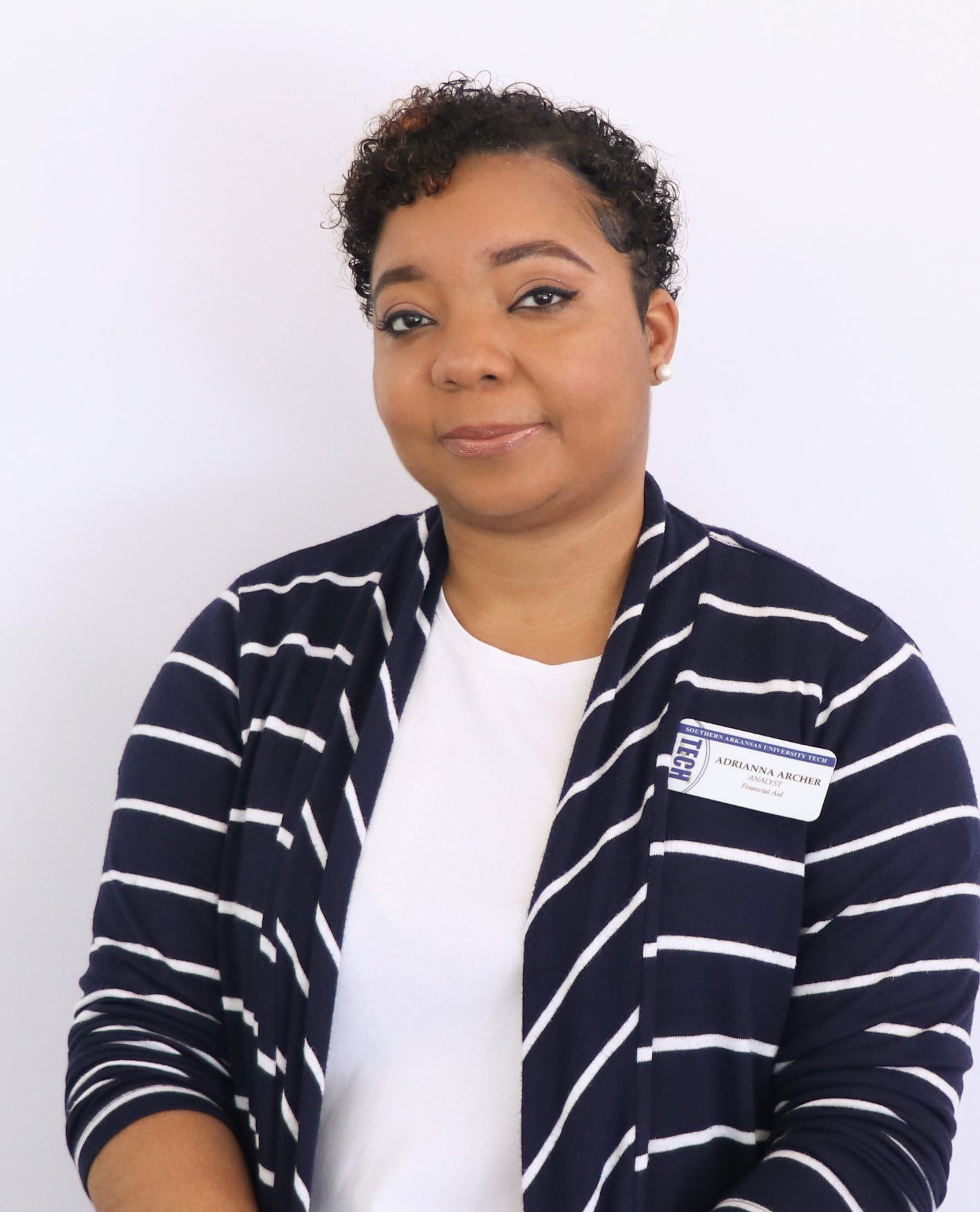 woman with short dark hair wearing a stripped cardigan