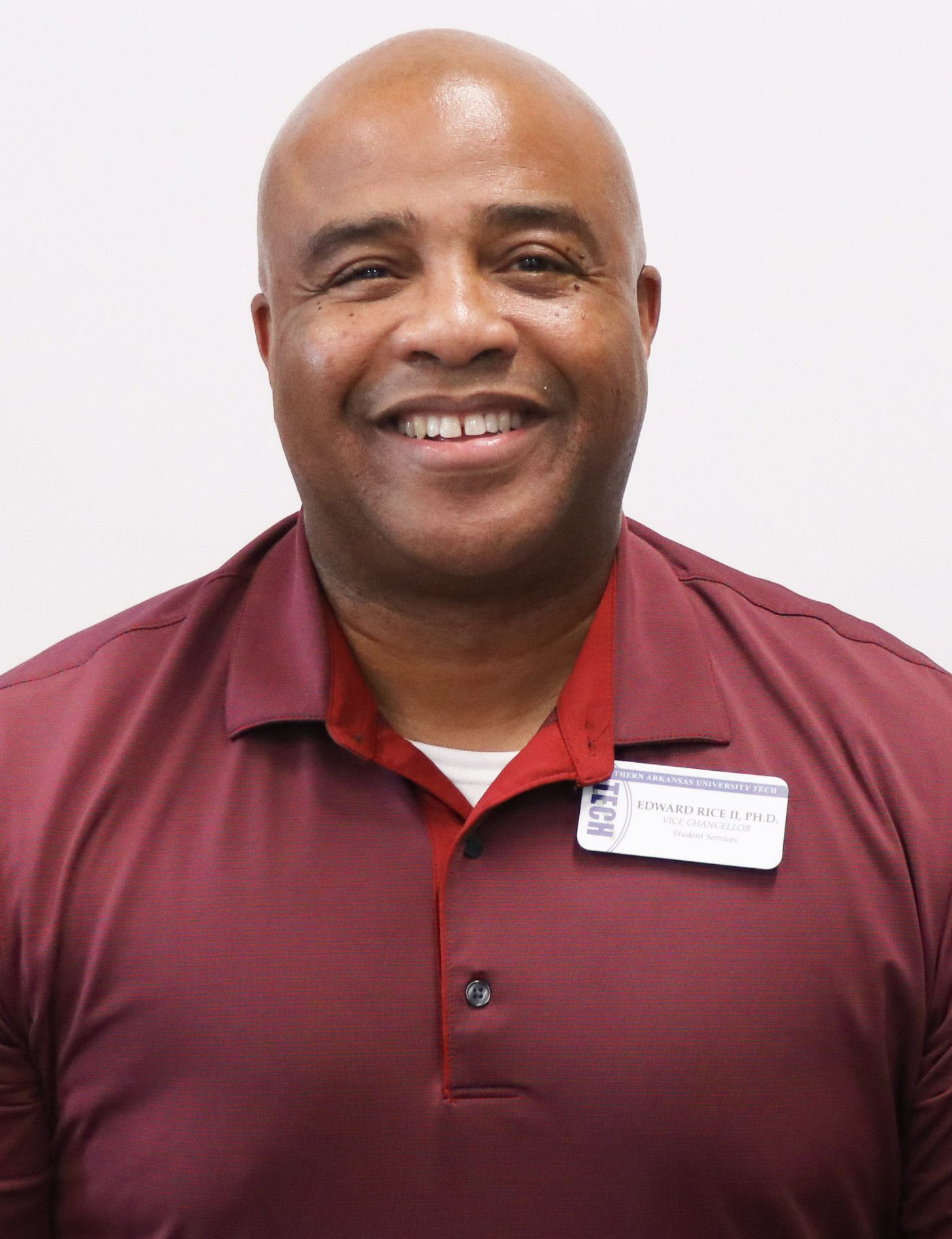man smiling a burgundy polo