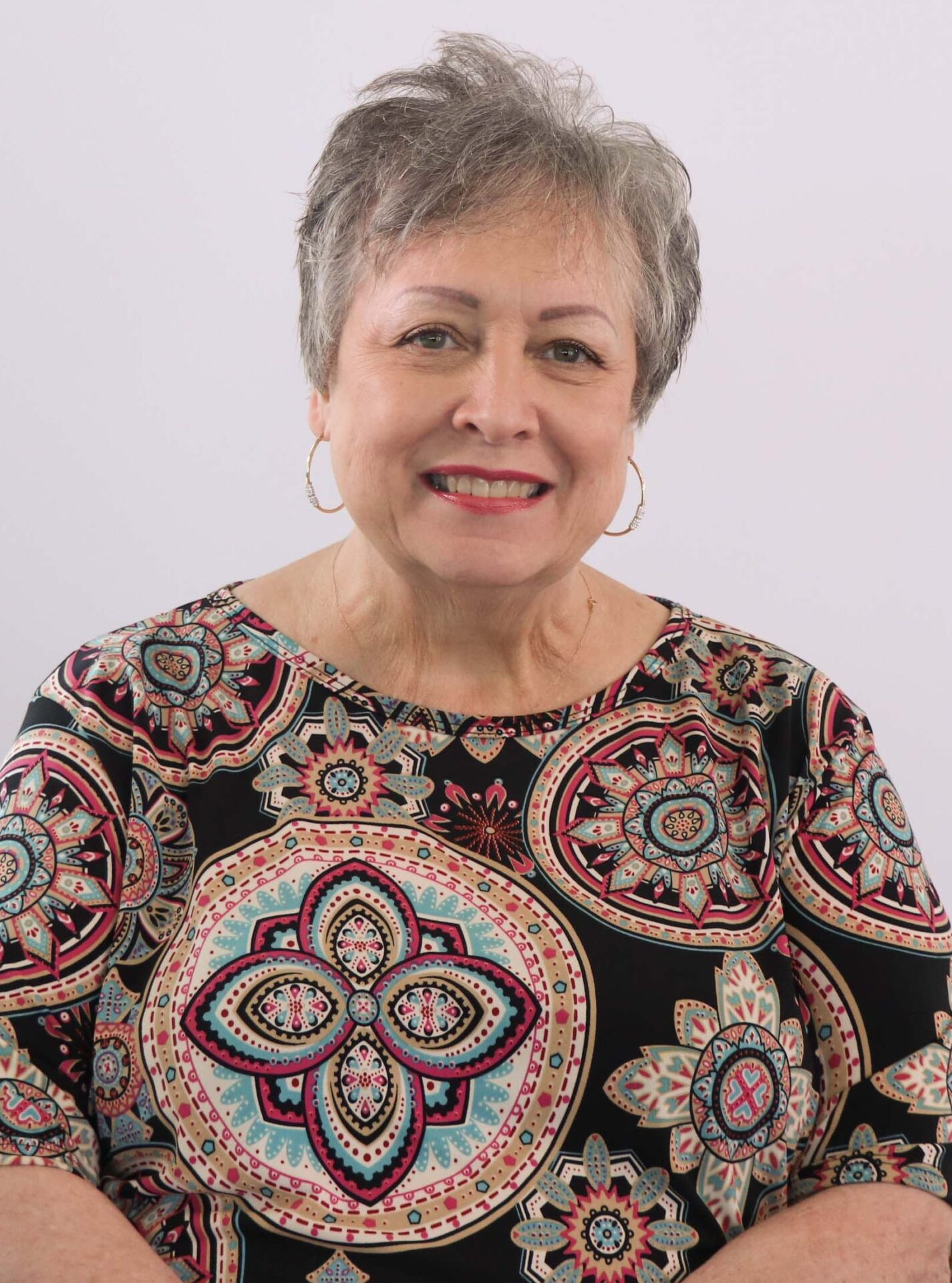 woman with gray hair wearing a paisley shirt