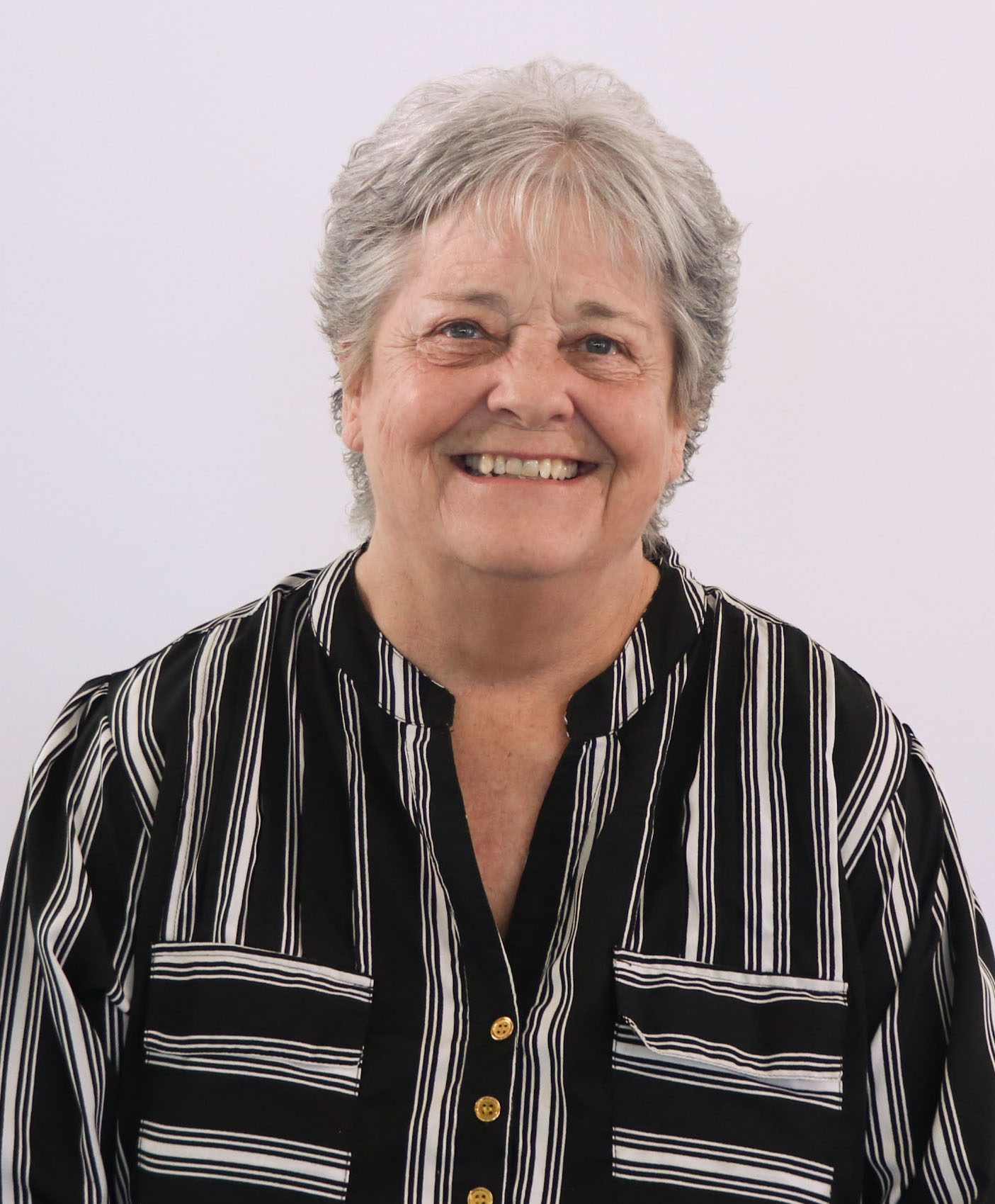 woman with short grey hair wearing a black and white stripe shirt
