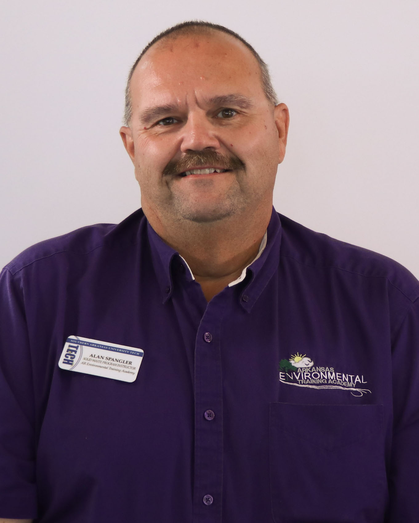 man with mustache in a purple shirt
