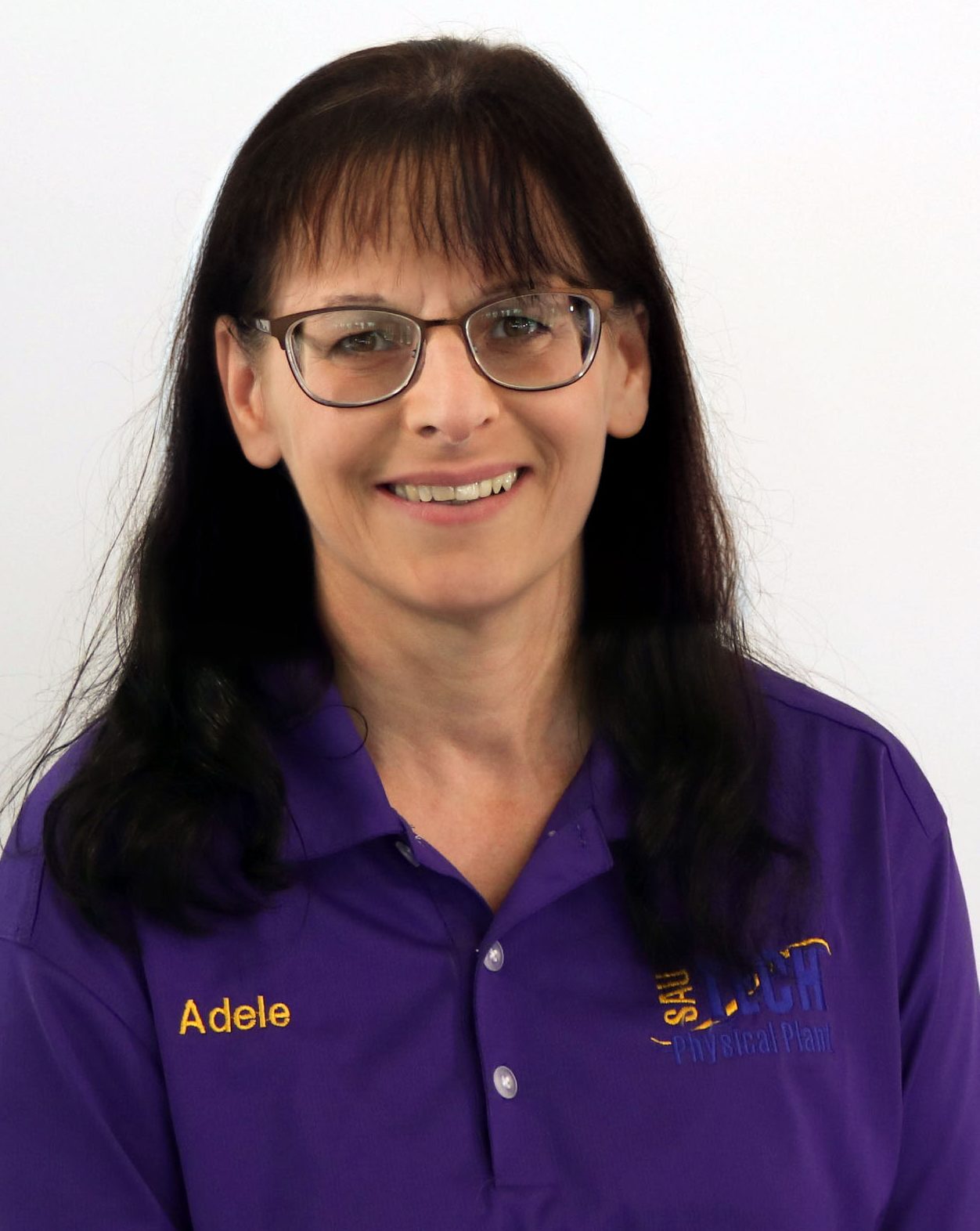woman in purple shirt with dark hair and glasses