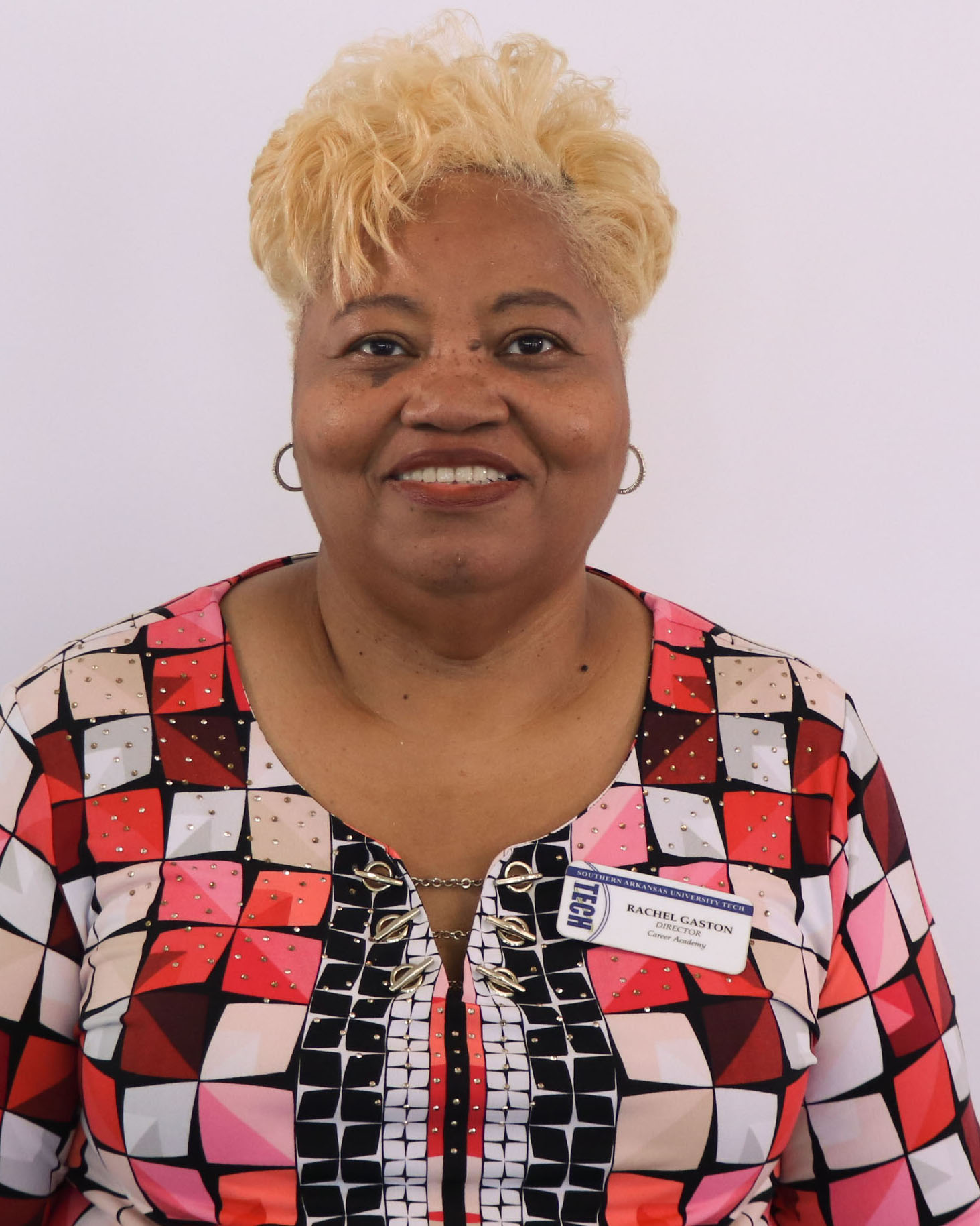 lady with short hair and patterned shirt smiling