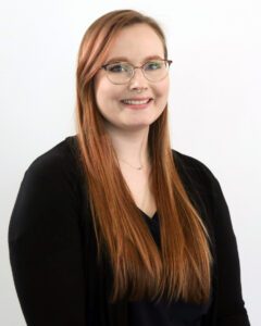 young woman with red hair and glasses