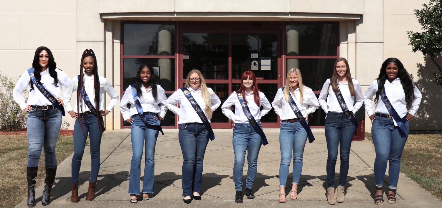 group of college girls wearing white shirts and homecoming ribbons