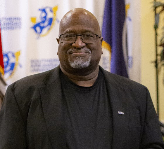 man smiling with glasses and a beard